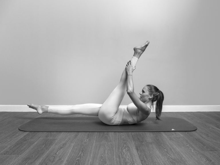 Monika demonstrating body awareness exercise inspired by pilates
